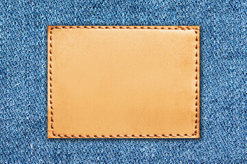 Fashion background with empty copy space for graphic design. Blank leather label tag. Blue jeans...