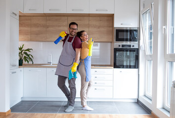 Couple doing their chores together cleaning apartment.