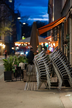 Closed restaurant with packed chairs outside during night