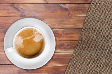 White Cup of Coffee on Wooden desk with burlap napkins