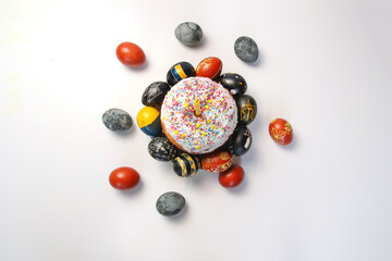 Defocus Easter table setting. Easter cake craffin. Close up Easter eggs pastel colored on white background. Minimal Easter celebration concept, dyed chicken egg. Top view. Out of focus