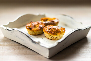 Three freshly baked homemade Easter cupcake muffins on white wooden vintage tray on table background
