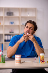 Young male dentist working in the clinic