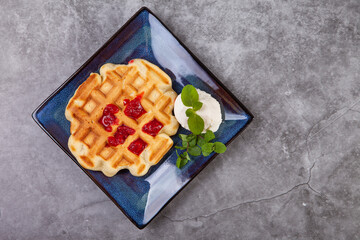 Homemade freshly baked belgian waffles with mint leaves on dark background. - 501011120