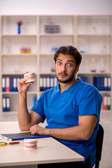 Young male dentist working in the clinic