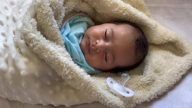 Sweet peaceful baby lying on a white bedsheet enjoy daytime nap