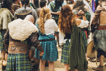 Fototapeta na wymiar Medieval Scottish warriors in a meeting to discuss battle tactics, all in the colors characteristic of their clans, using their kilts to differentiate themselves.
