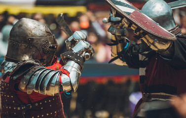 Pitch battle of medieval knights, using metal armor, axes, swords and shields to defend themselves.