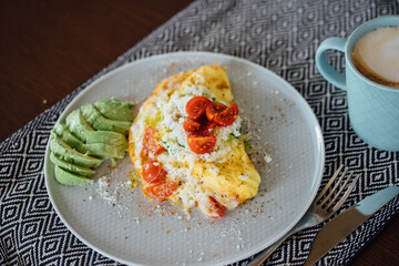 Plate with homemade breakfast: omelet with cheese and tomatoes.