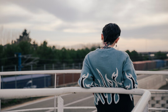 Unrecognizable girl with a tattoo on her head looking at the horizon