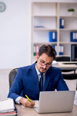 Naklejka premium Young male employee working in the office
