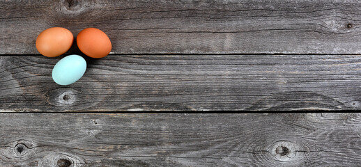 Naklejka na ściany i meble Three chicken eggs on rustic wooden table