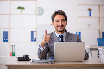 Young male employee sitting at workplace