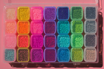 colored beads in a plastic box close-up