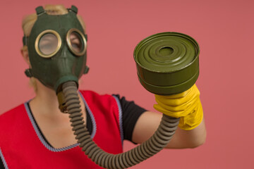 cleaning lady in a gas mask, apron and gloves, portrait on a colored background, studio shot