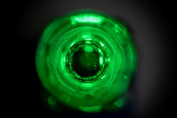 vista cenital de botella de vidrio con agua teñida de verde y poca profundidad de campo