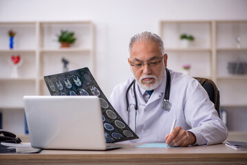 Old male doctor radiologist working in the clinic