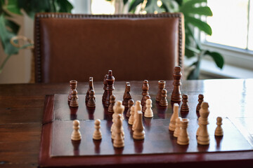 Wooden board with chess game on a table