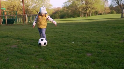 Happy Family Of Children Having Fun In Spring Park. Little Kid Run. Child Girl Dribbles Black White Classic Soccer Ball On Green Grass. People Playing Football. Childhood, Sport, Championship Concept