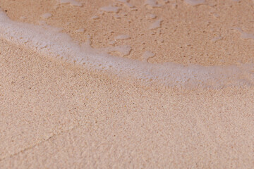 Bubbles waves and sand on the beach texture background.