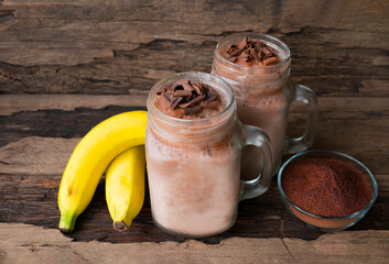 Cocoa mix banana  fresh milk vanilla smoothies fruit juice beverage healthy the taste yummy in glass drink episode good morning on wooden background.