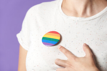 Woman with a rainbow flag badge, symbol of support for the LGBT community.