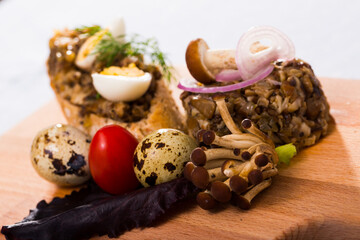 Gourmet mushroom tartare served with slice of baguette, quail egg, tomato and fresh greens