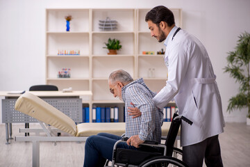 Old man in wheelchair visiting young male doctor