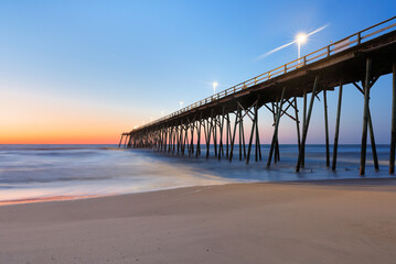 Fototapeta na wymiar Kure Beach Fishing Pier before sun rise, Kure Beach, North Carolina, USA. 
