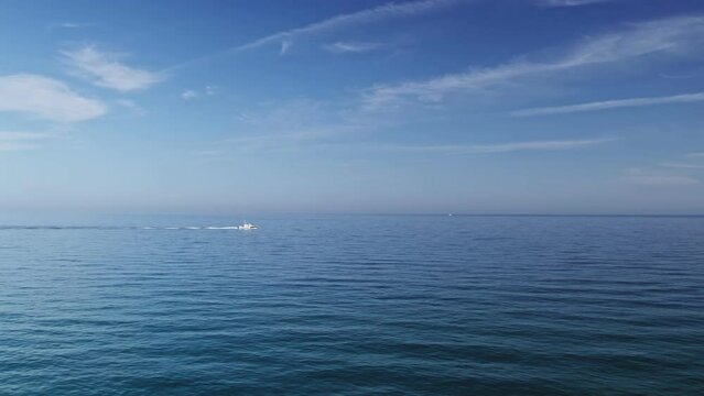 Calm blue ocean with boat passing by