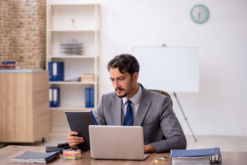 Young male employee sitting in the office