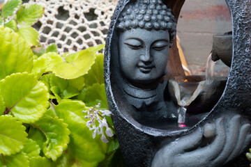 buddha statue image on altar with candles and plants