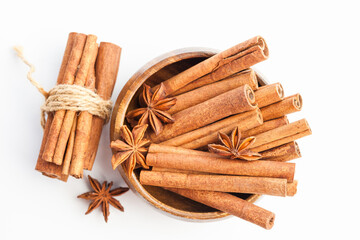 Anise stars and cinnamon sticks in a wooden bowl isolated on white background. Aromatic spices