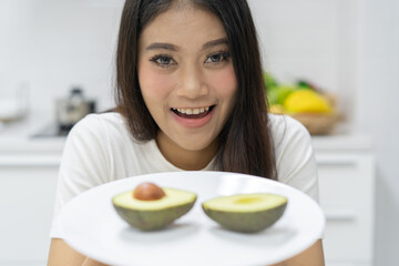 Woman showing avocado for breakfast.