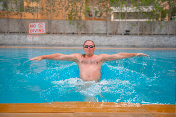 adult male swims in a large pool