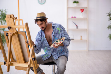 Young man enjoying painting at the studio