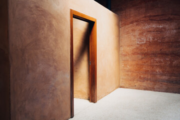 Interior door design of neat cob house with concept of light and earth.