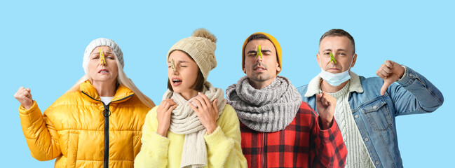 Ill people with clothespins on their noses against light blue background