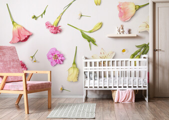 Interior of modern children's room with crib and armchair near wall with print of flowers