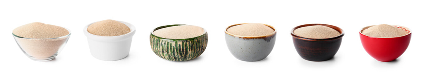 Set of bowls with dry yeast on white background