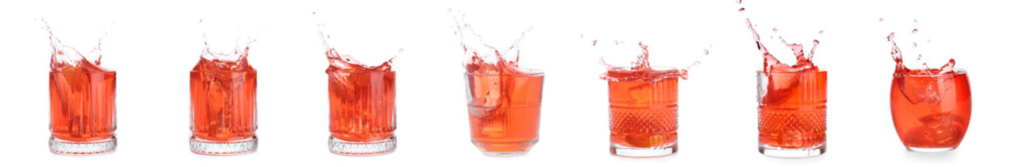 Glasses of tasty Negroni cocktail with splashes isolated on white