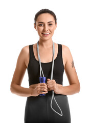 Sporty young woman with skipping rope on white background