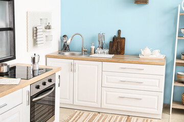 Obraz premium Wooden counters with silver sink and cookware in kitchen