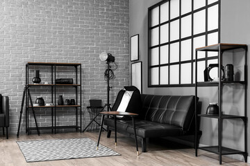 Interior of modern photo studio with shelving units, couch and professional equipment