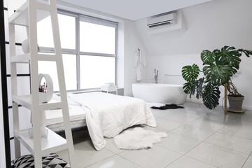 Stylish interior of bedroom with bathtub