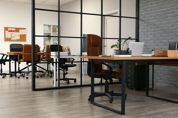 Interior of modern office with workplace near grey brick wall