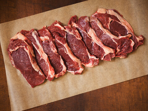 Raw Grass Fed Rib-Eye Steaks on Parchment Paper