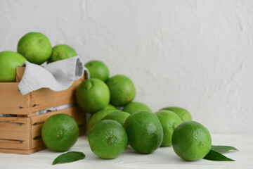 Fresh ripe limes on light wooden table