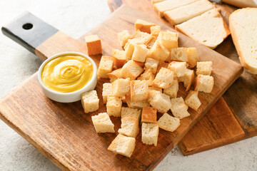 Board with tasty croutons and sauce on white background, closeup