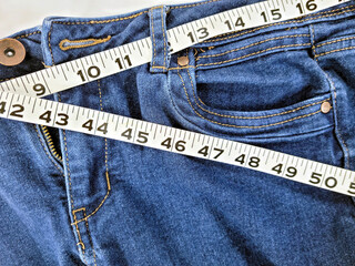 Close up of tape measure in denim blue jean waistband